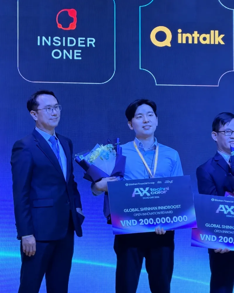 On stage at Shinhan Financial Group's AX Technicolor Demo Day 2026, under the intalk logo, an Intalk representative holds a board reading Global Shinhan InnoBoost Open Innovation Reward, VND 200,000,000.